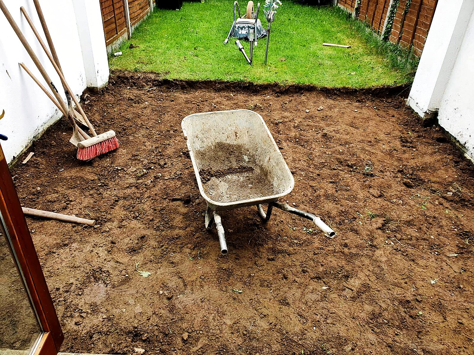 Patio area dug out with wheelbarrow and tools